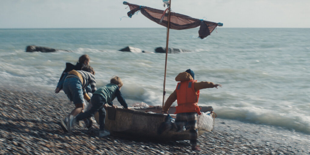 A group of boys running with a boat