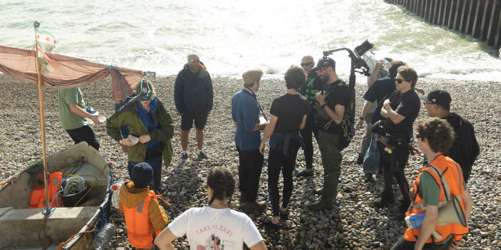 Film crew stood on a rocky beach