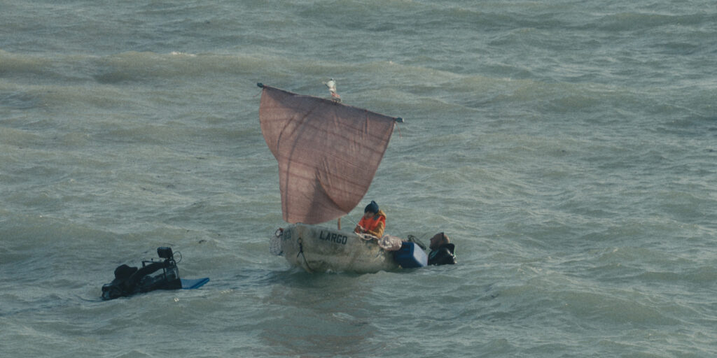 Film crew with a small boat at sea