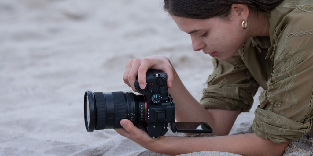 A woman using a camera on the beach