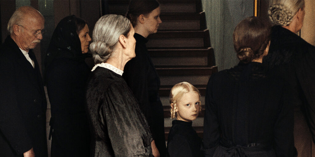 A group of adults with a child looking into camera