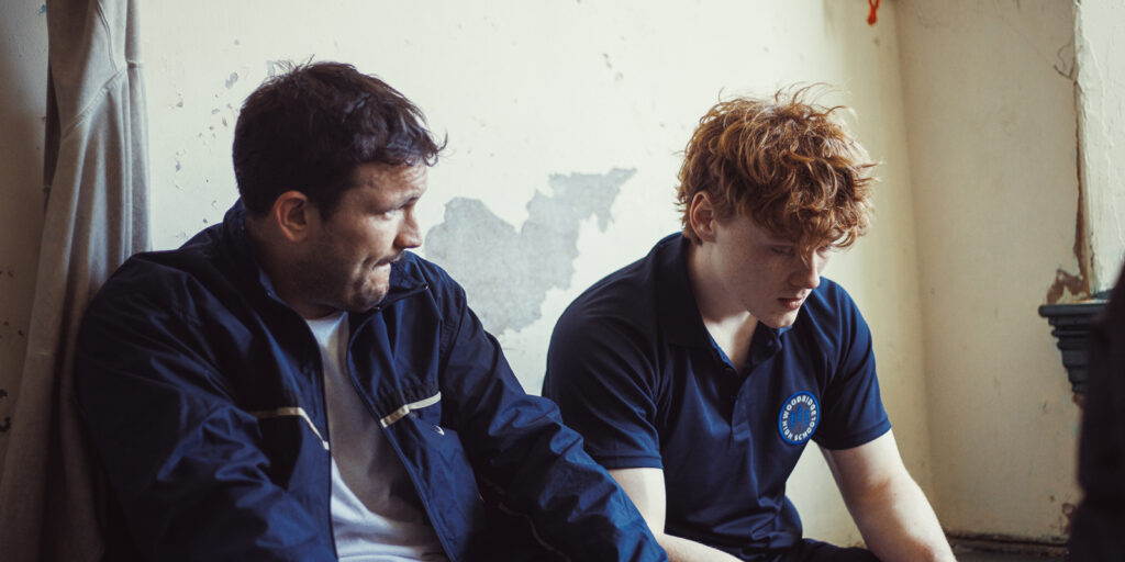 A boy and man sat in a changing room