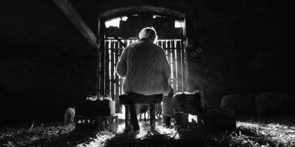 A man sat in a barn