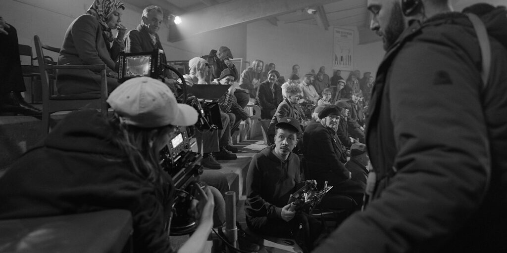 Film crew sat in a busy room