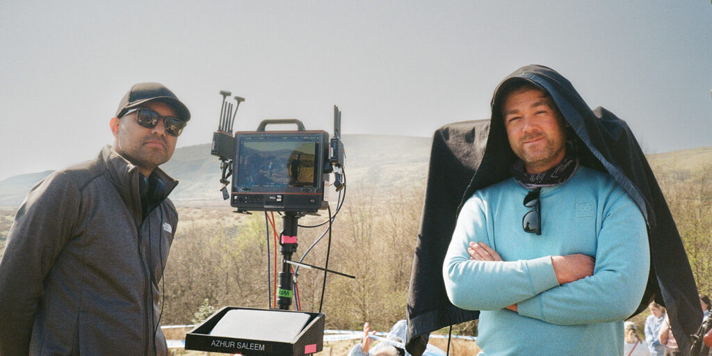 Two people stood in a field on set