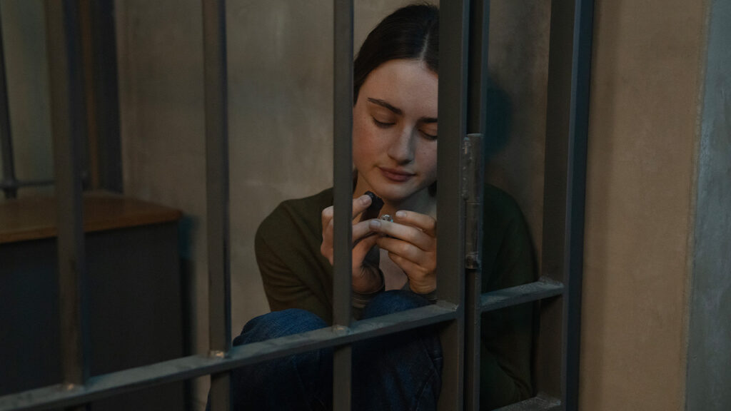 A woman sat in a prison cell