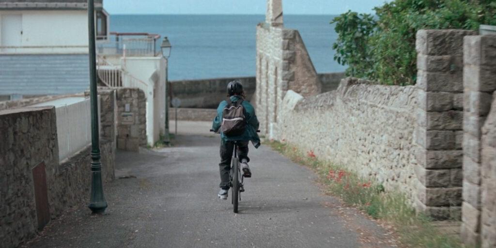 A person on a bike cycling in a seaside village 