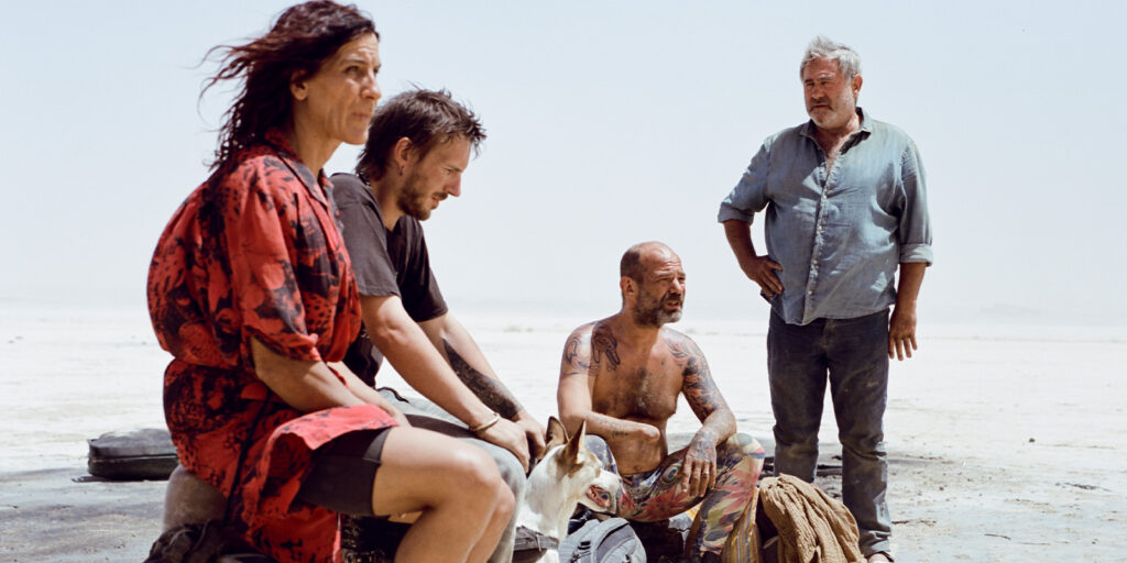 Four people sat in the desert