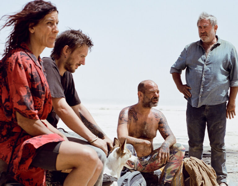 Four people sat in the desert