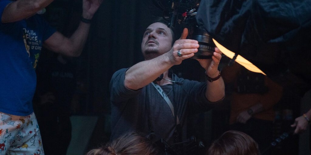 Caleb Heymann holding a camera and looking upwards