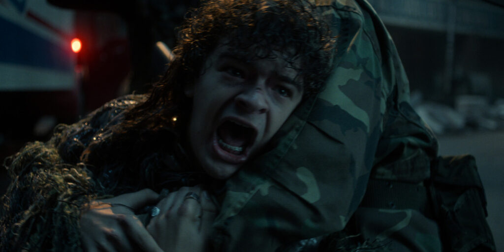 A man screaming in the arms of a soldier