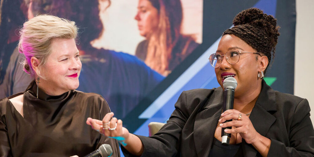 Two women sat together smiling