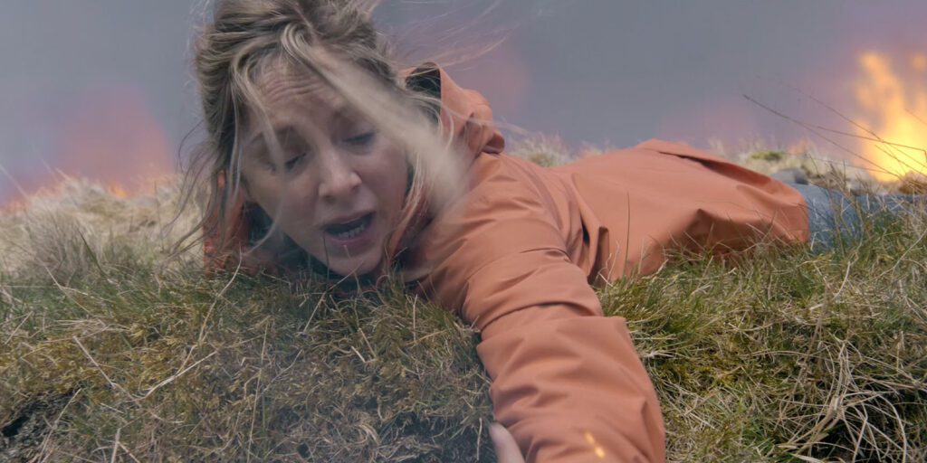 A woman in an orange jacket reaching out