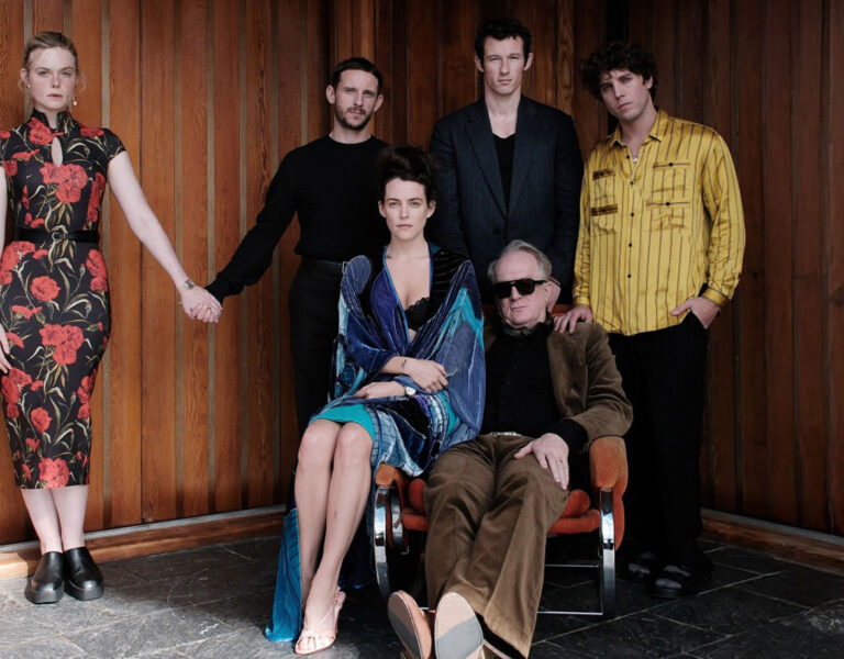 A group of people posing by a wooden wall