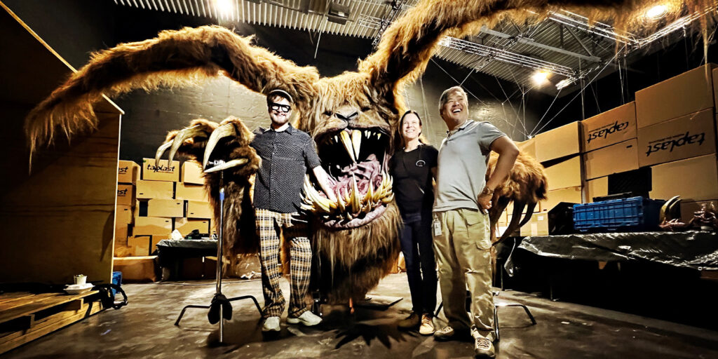 A group of people with an animatronic monster