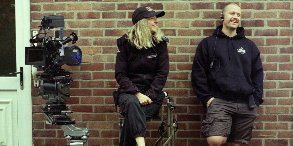 Two people standing by a wall