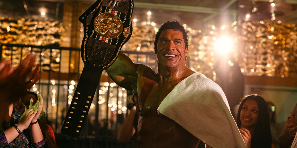 The Rock holding a belt and smiling