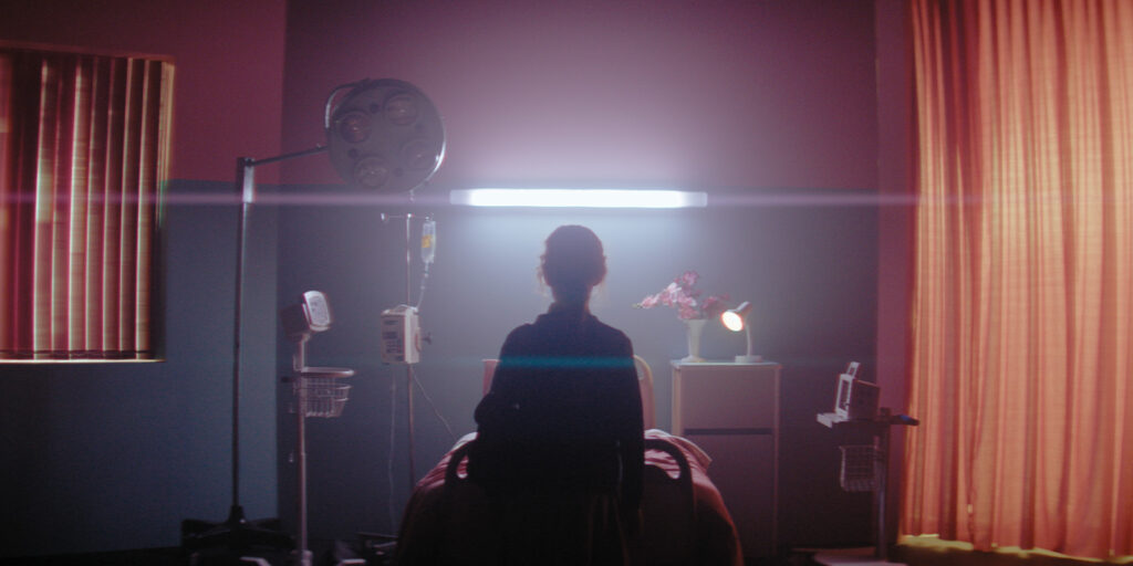 A person stood by a hospital bed