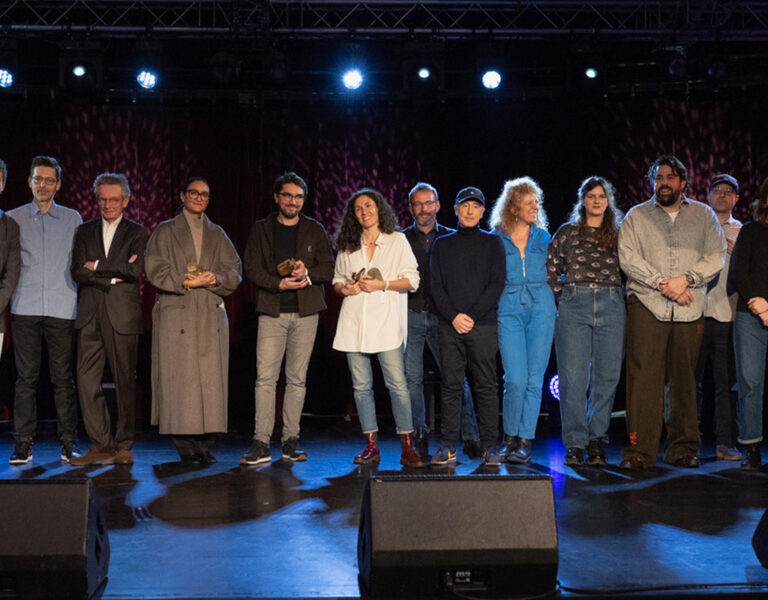 A group of people posing on stage
