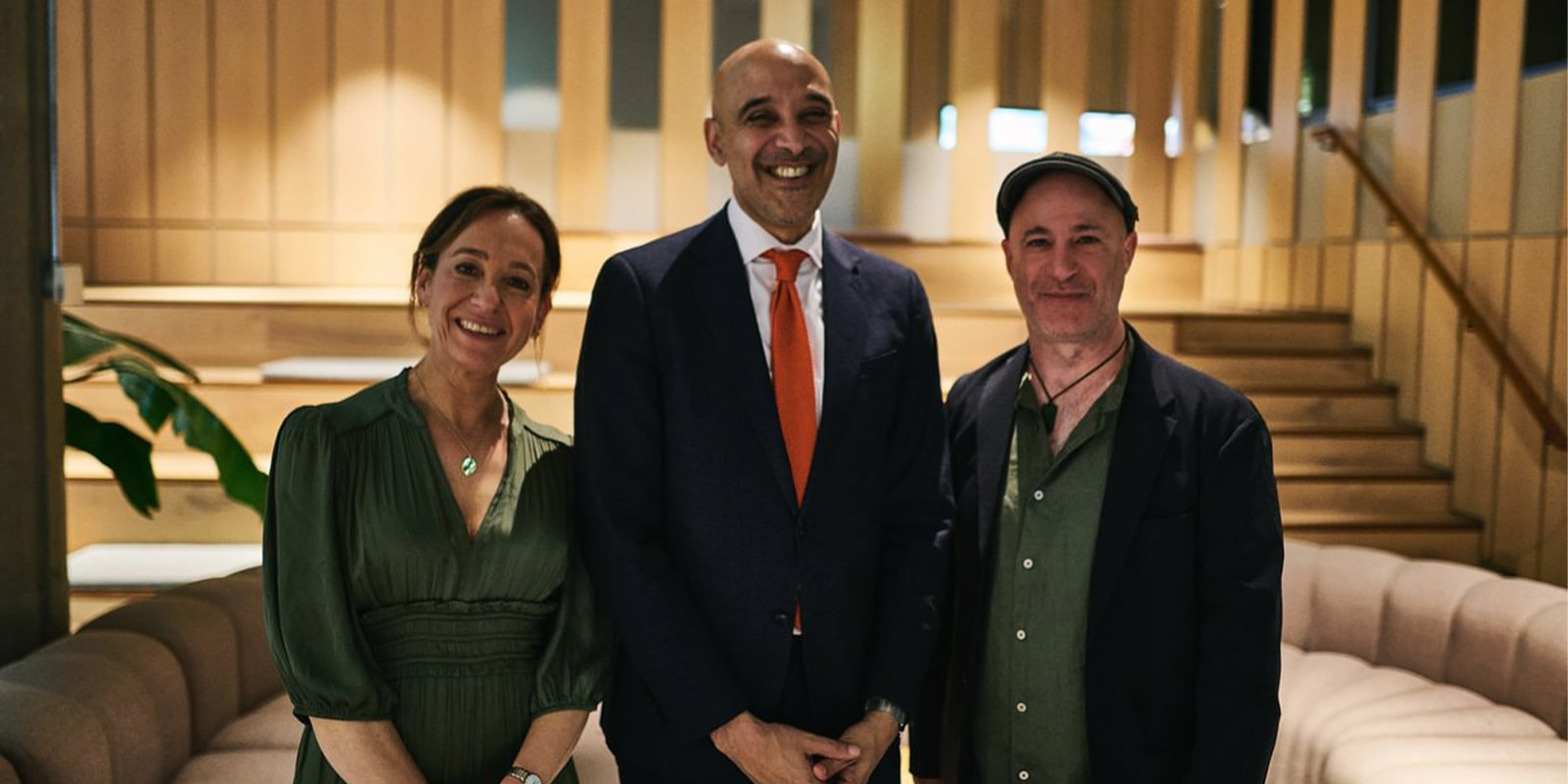 Three people stood together smiling