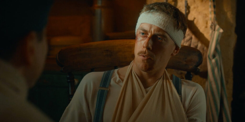 A man with a bandage wrapped around his head and a sling supporting his arm sits in a wooden chair, looking to the left. The warm lighting and rustic cabin setting evoke an adventure from The Famous Five.