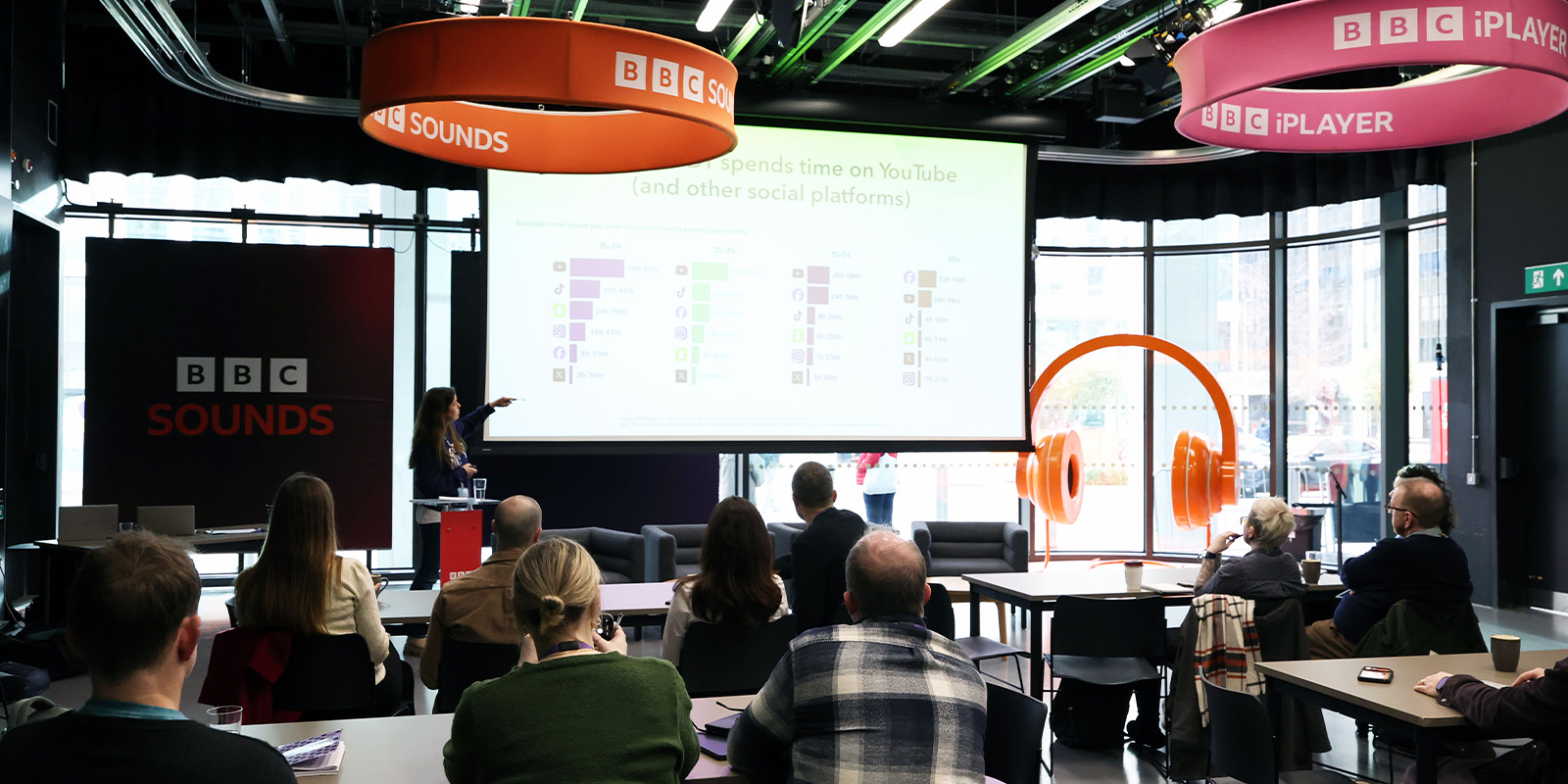 A BBC studio with people watching a presentation