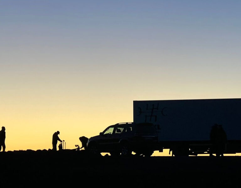 Silhouettes of five people, a pickup truck, and a large box lorry are visible against a sunset sky—a perfect scene reminiscent of The Fires or an Ollie Downey film for BSC enthusiasts.