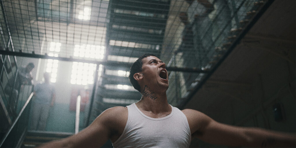 A prisoner in a vest screaming 