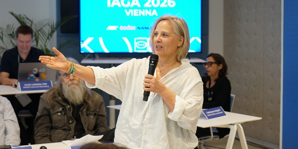 A woman standing and talking into a microphone 
