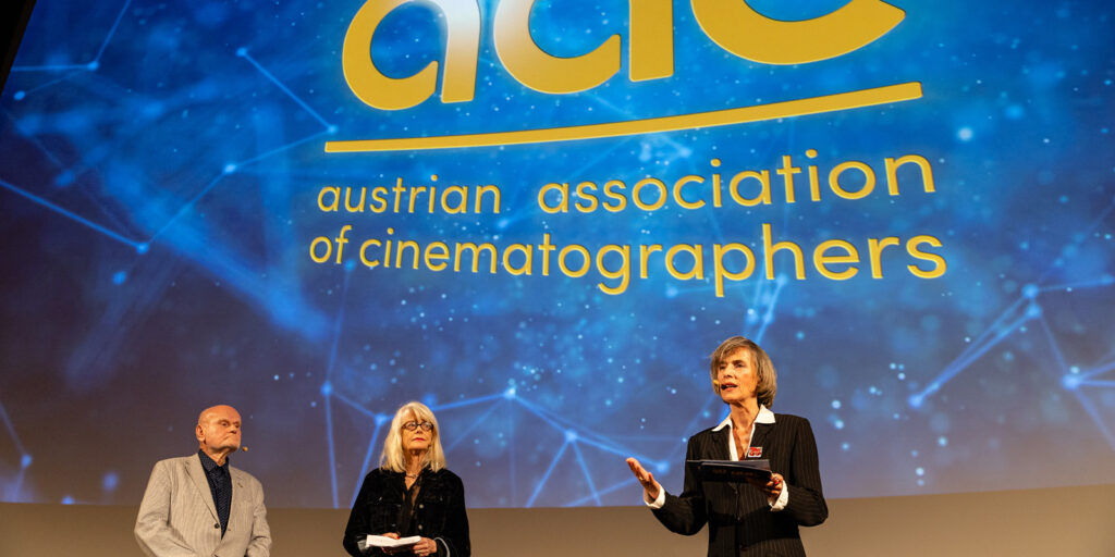 Two people stood on stage giving a talk 
