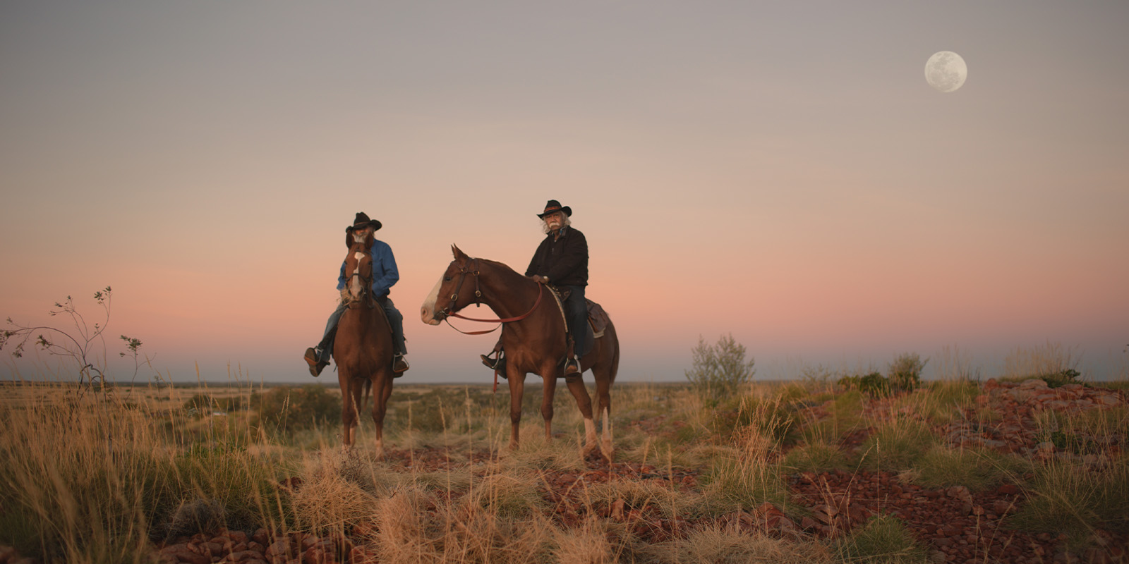 Two men on horseback looking into camera