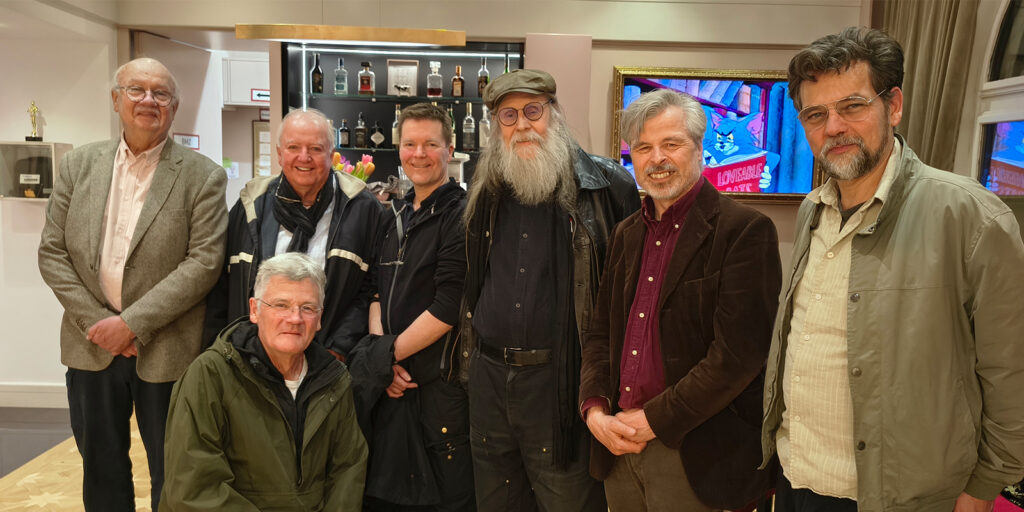 A group of people posing together in front of technological equipment