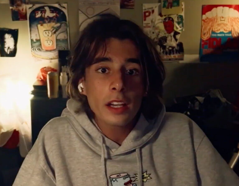 A man sat in a grey hoodie