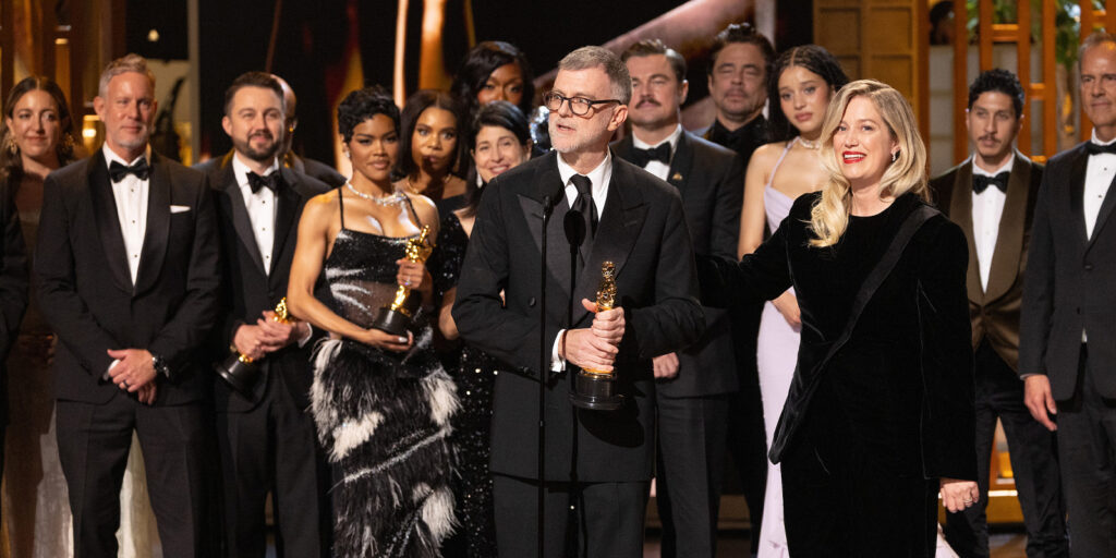 A group of people in formal attire celebrating together on stage