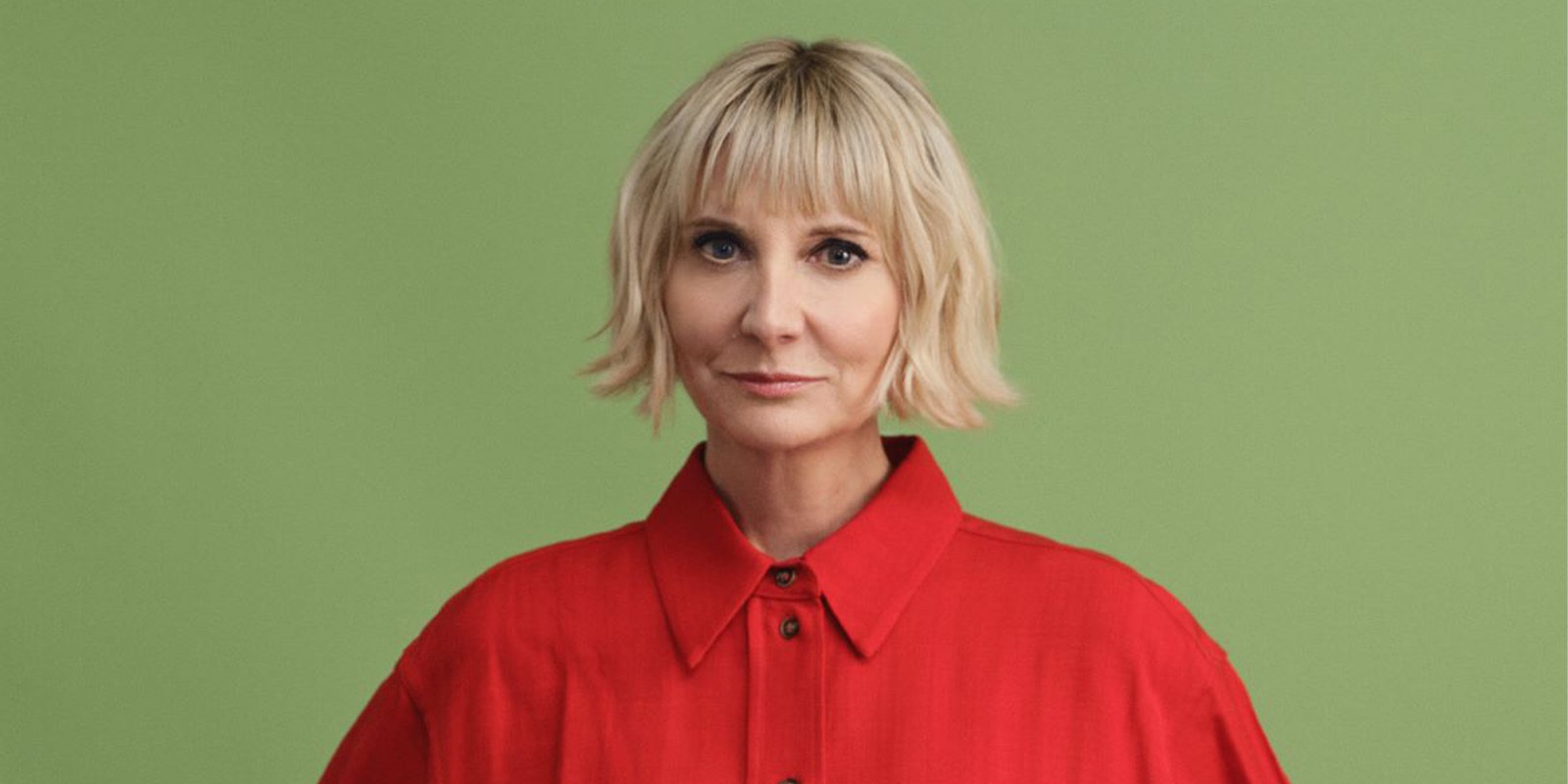 A woman in red looking into camera