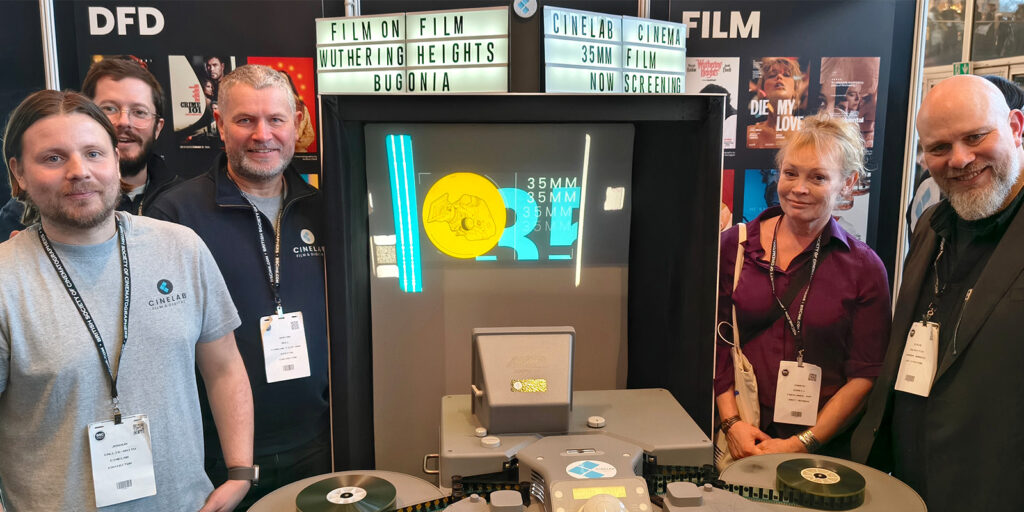 Five people stand around a film reel display featuring a sign that reads “FILM ON FILM WUTHERING HEIGHTS BUGONIA” and “CINEVAR CINEMA 35MM FILM NOW SCREENING” at the BSC Expo 2026. Posters and banners are visible in the background.