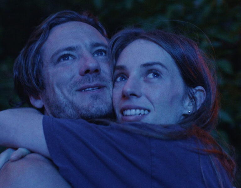 Two people hugging in blue light