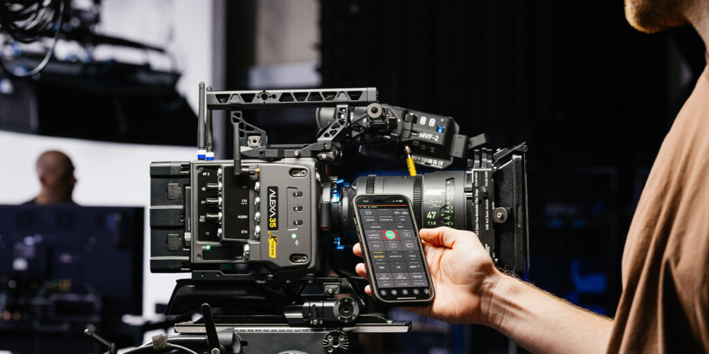 A person operating a phone behind a camera