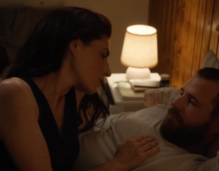 A man and woman lying on bed together