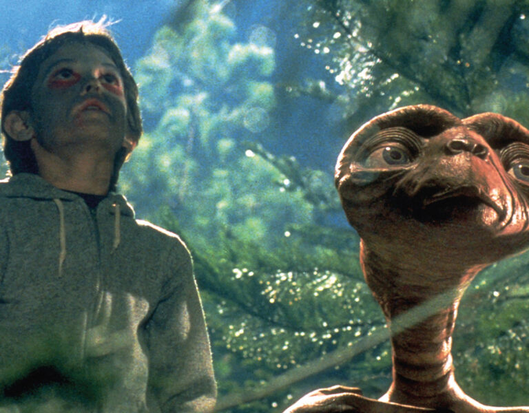 A boy and ET look skywards