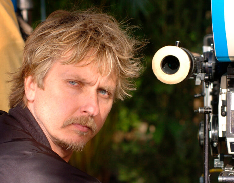A man stood by a camera looking serious