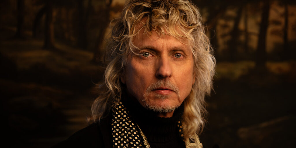 A man wearing a scarf looking into camera