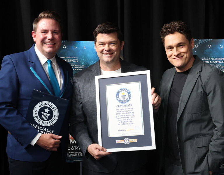Three people posing together with a Guinness World Record certificate