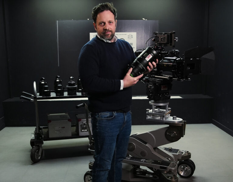 A man standing with a large lens in his hand