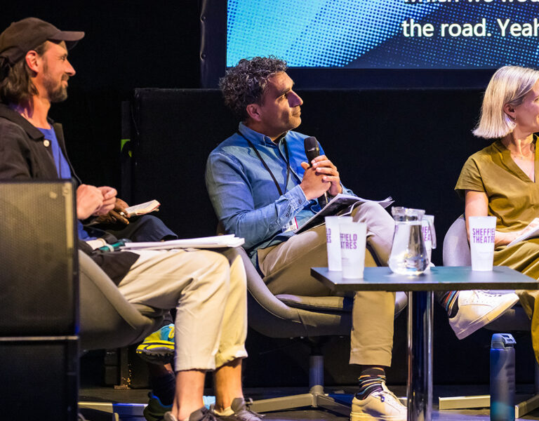 Three people sat on stage for a panel