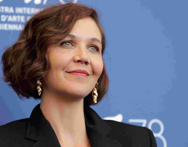 Maggie Gyllenhaal on a red carpeting smiling