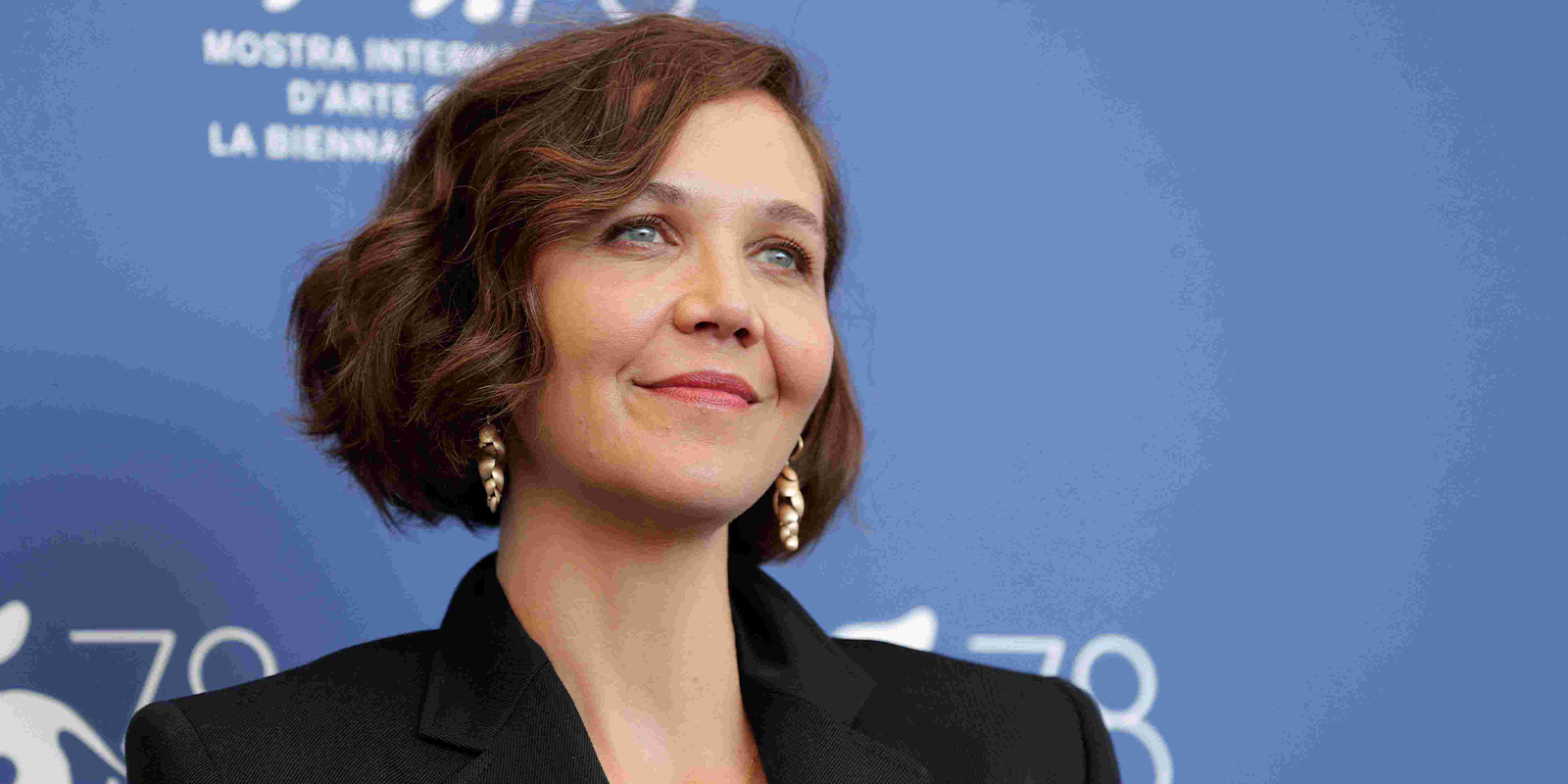 Maggie Gyllenhaal on a red carpeting smiling