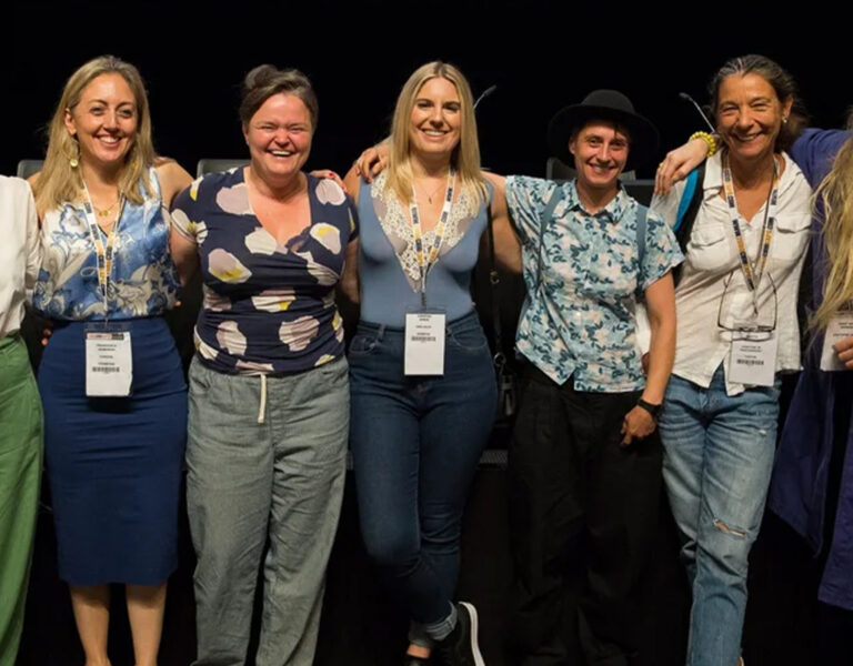 A group of people standing together hugging and smiling