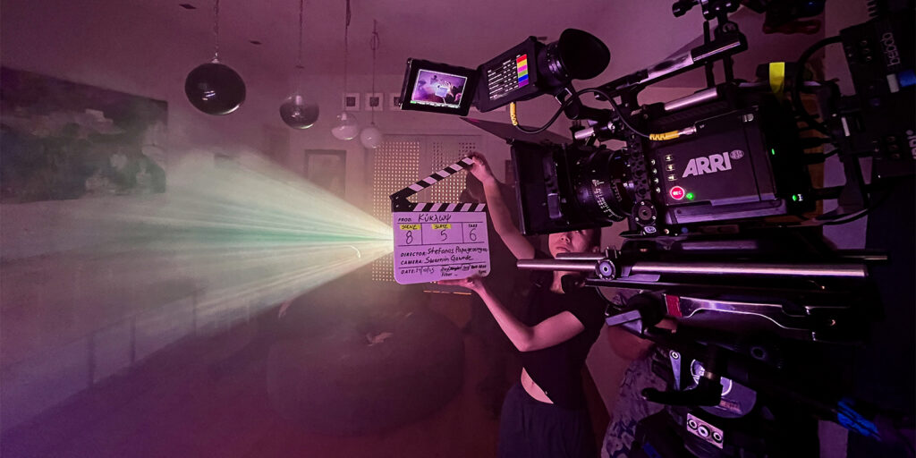 A person holding a clapperboard in front of a camera