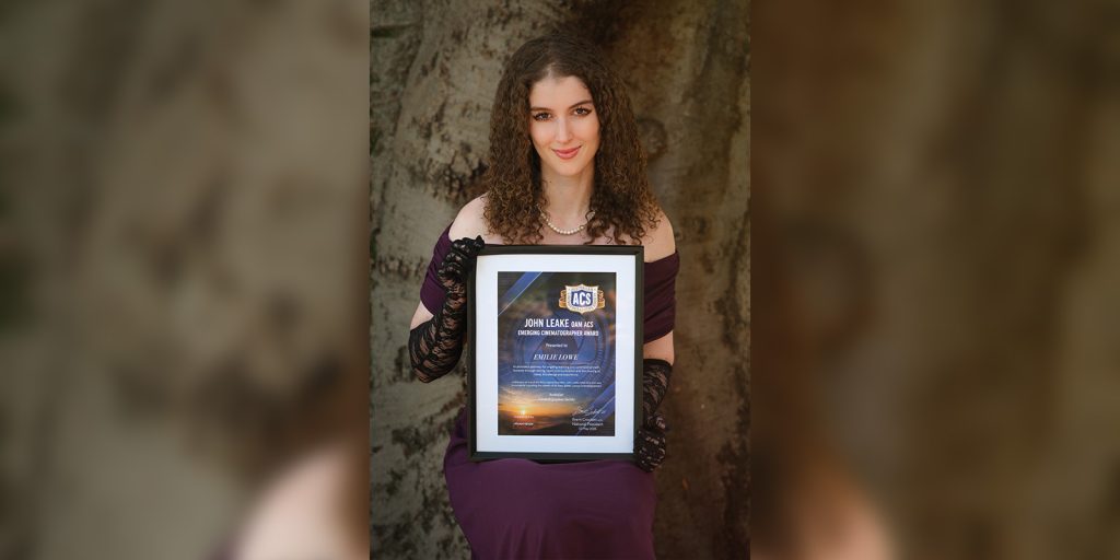 Emilie Lowe posing with an award